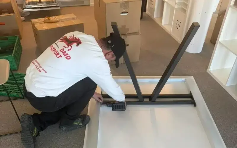 Déménageur de DMD-Transport en train de monter un bureau