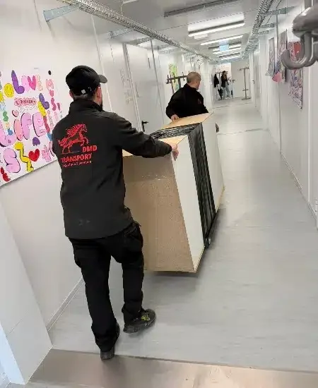 Les déménageurs de DMD-Transport en train de transporter un meuble dans une école