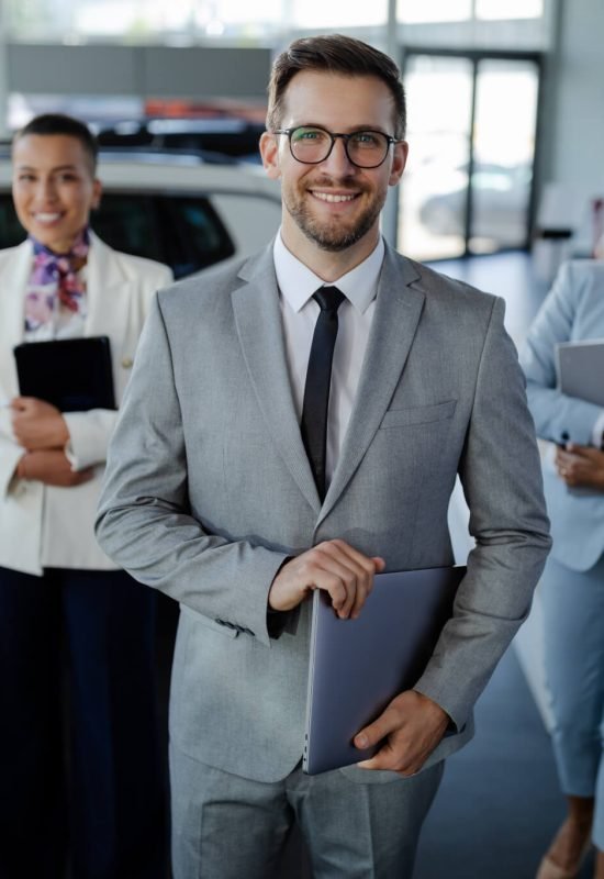 Salesteam In Dealership Three Beautiful Consultants Or Managers In Elegant Suit Looking On Camera .jpg